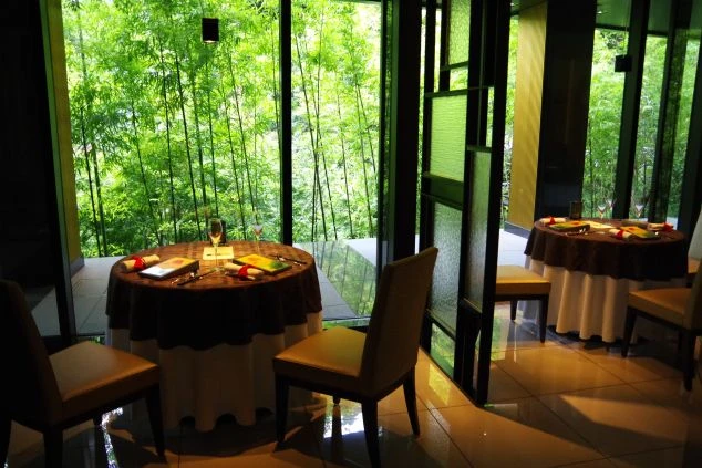 リゾートバイトの勤務先となる高級ホテルのレストラン内観。竹林が見える窓際のテーブル席。