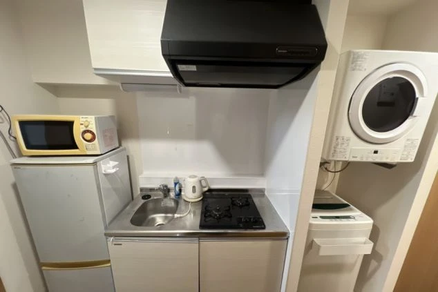リゾートバイトの完全個室寮のキッチン・冷蔵庫・電子レンジ・洗濯機・乾燥機の画像。