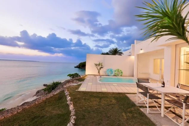 沖縄のリゾートバイト求人イメージ。海が一望できるプライベートプール付きホテルのテラスと夕景