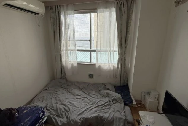 海が見えるリゾートバイトの個室寮の画像。窓から熱海の景色が望める、エアコン完備の明るいワンルームタイプの居室。