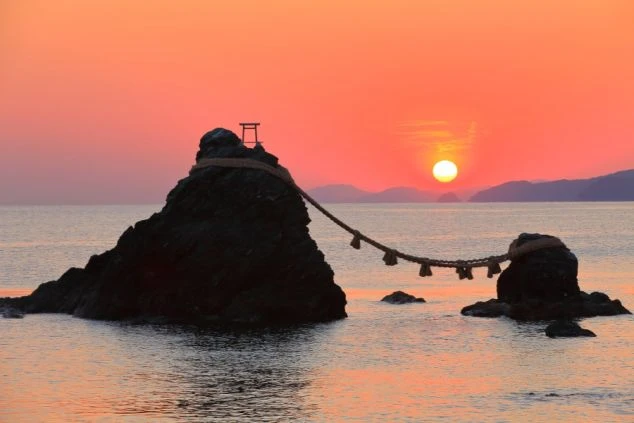 燃えるような朝焼けの海に浮かぶ夫婦岩。リゾートバイトの休日に拝みたい、伊勢エリアの神聖な日の出の景色。