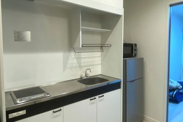 寮のキッチン。IHコンロ、シンク、冷蔵庫、電子レンジがコンパクトにまとまり、自炊に便利な環境。