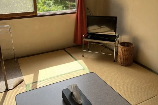 リゾートバイト先の相部屋寮の部屋全体の画像。畳の共用スペースがあります。