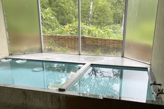 リゾートバイト先の相部屋寮にある共用の大浴場の画像。