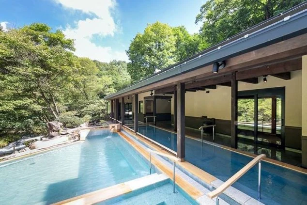 自然豊かな景色を望む開放的な露天風呂。温泉旅館のリゾートバイトで人気の就業先イメージ。