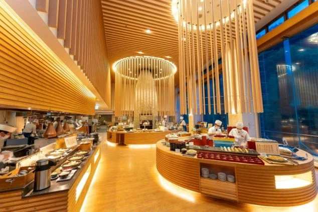 豪華なホテルのビュッフェレストラン会場。リゾートバイトの配膳や調理補助スタッフが活躍する職場環境。