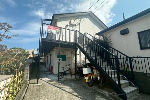 日当たりが良く落ち着いた住宅街に位置する、2階建てのスタッフ専用寮の外観画像。