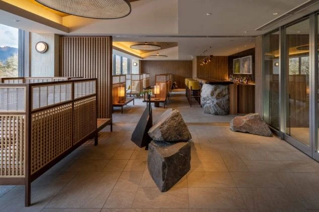 大きな岩のオブジェや格子状の仕切りが美しい、高級感あふれるリゾートホテルのロビーの画像。