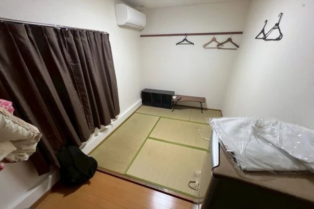 和室の個室。畳の上に小さなローテーブルと棚があり、壁にはハンガーが掛けられている。
