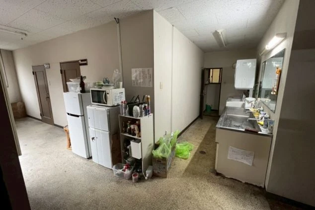 共有スペース。冷蔵庫、電子レンジ、炊飯器などの家電と、ステンレス製の流し台が並んでいる。