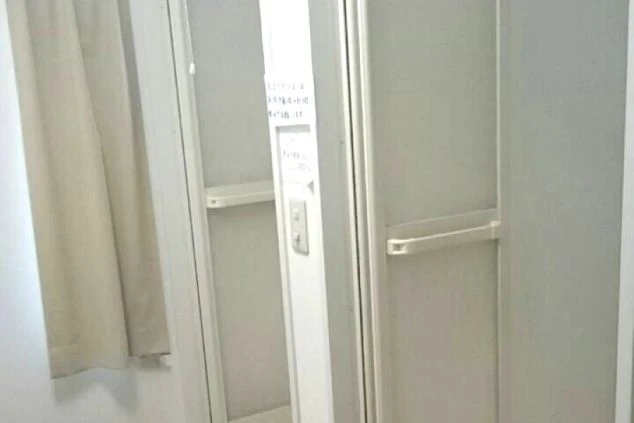 寮内のシャワールーム入口。白い扉が並び、清潔感のあるコンパクトな設計になっています。