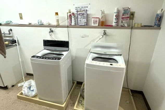寮内の共用洗濯機スペースの画像。長期滞在のリゾートバイトスタッフも安心して利用できる洗濯設備。