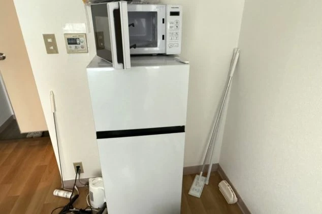 個室寮に備え付けられた冷蔵庫と電子レンジの画像。リゾートバイト中の生活を快適にする充実の生活家電。