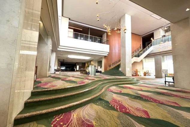 華やかな装飾が施されたホテルの広大なロビーと吹き抜けの階段。一流の接客スキルが身につく、リゾートホテルの業務。