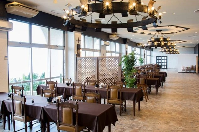 ホテル内の開放的なメインダイニングの画像。アンティーク調の豪華なシャンデリアが灯るレストランで、一流の接客スキルを磨ける職場。