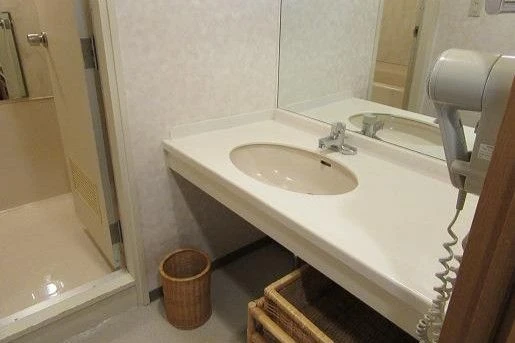 鏡付きの独立洗面台とドライヤーが完備された寮の脱衣所。毎日の身支度もスムーズに行える、清潔感のある個室寮の設備。