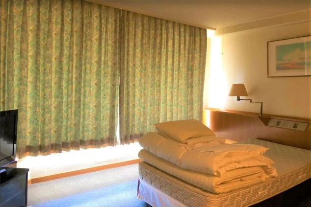 テレビやベッドが完備された明るい個室寮の室内。仕事終わりもプライベート空間でリラックスできる住み込み環境。