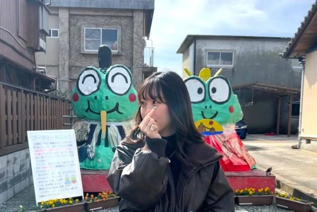 伊勢神宮内宮門前「おかげ横丁」の提灯の前でポーズをとる女性スタッフ。食べ歩きや名所巡りを楽しめる、三重県伊勢エリアの住み込み求人。