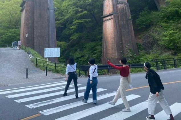 群馬県安中市の観光名所「めがね橋（碓氷第三橋梁）」を観光するグループ。軽井沢エリアからも近く、休日に仲間と歴史的建造物や自然を楽しめる住み込みバイトの休日イメージ。