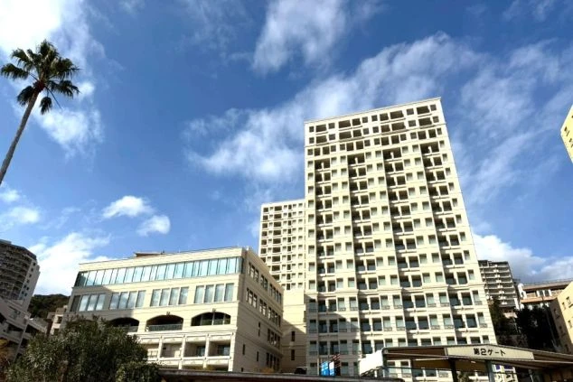 青空の下に建つ白を基調とした高層ホテルの外観。