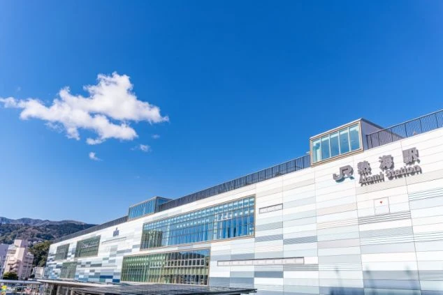 晴天の下に建つ、ガラス張りのモダンな熱海駅舎の外観