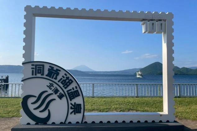 洞爺湖と遊覧船を背景にした、白い切手型のフォトフレームオブジェ。