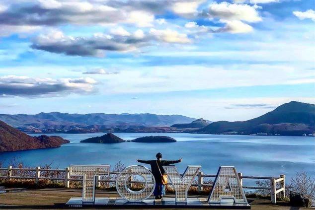 「TOYA」の文字オブジェ越しに、広大な洞爺湖と中島を望むパノラマ絶景。