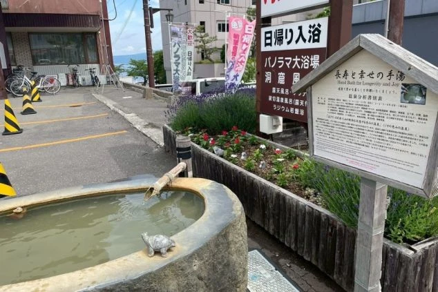 洞爺湖温泉街にある「長寿と幸せの手湯」と温泉分析書。