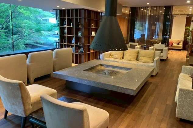 中央に暖炉を配したホテルのラグジュアリーなラウンジ。洗練された空間で一流のホスピタリティを学べるリゾートバイトの職場環境。