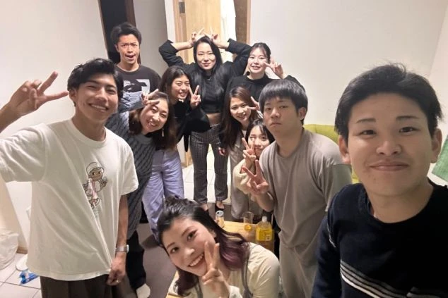 リゾートバイトで出会った若者たちの集合写真。寮の共有スペースで交流を楽しむ大勢の仲間たち。