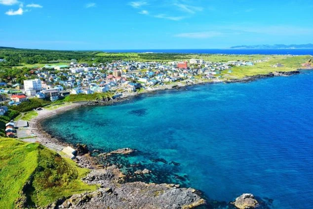 澄み渡る青い海と礼文島の静かな街並み。北海道・離島エリアのリゾートバイト求人の画像。