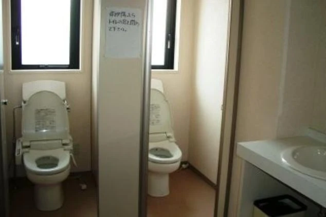 清潔感のある共用トイレ。温水洗浄便座付きの洋式トイレが並び、手前には白い洗面台が設置されている。