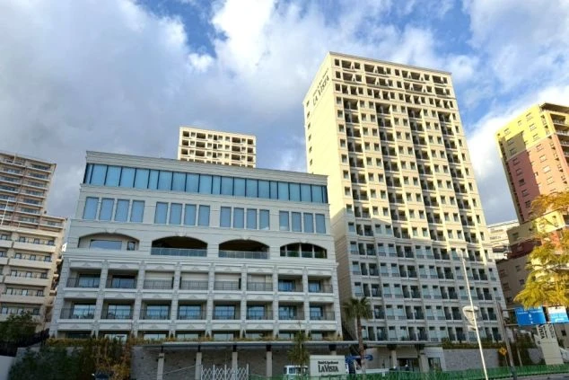 青空の下に建つ白を基調とした高層ホテルの外観。