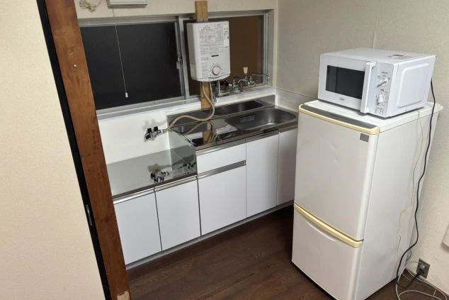 自炊用キッチン設備の画像。コンロやシンクが備わり、休日の食事作りにも便利なリゾートバイトの生活環境。