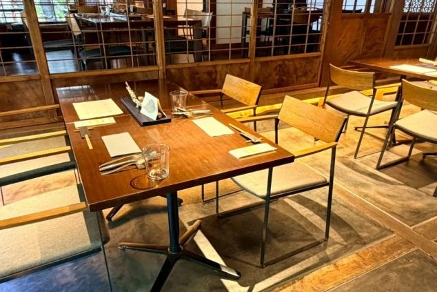 スタイリッシュな黒の制服を着用したレストランホールスタッフにイメージ画像。接客マナーやスマートな立ち振る舞いが身につくリゾートバイトの仕事風景。