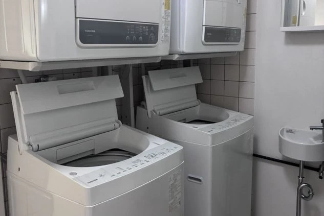 リゾートバイト住み込み寮の共用設備。洗濯機と乾燥機が完備されており、毎日の生活もスムーズで便利。
