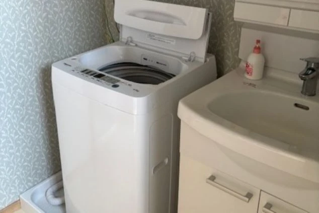 リゾートバイトの寮の個室にある、独立洗面台と洗濯機。自分専用なので、時間を気にせず身支度や洗濯ができます。