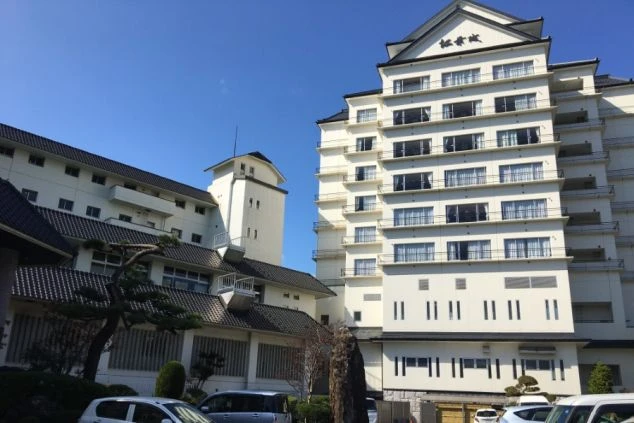 城を模したデザインが特徴的な、白壁の大型旅館の外観。