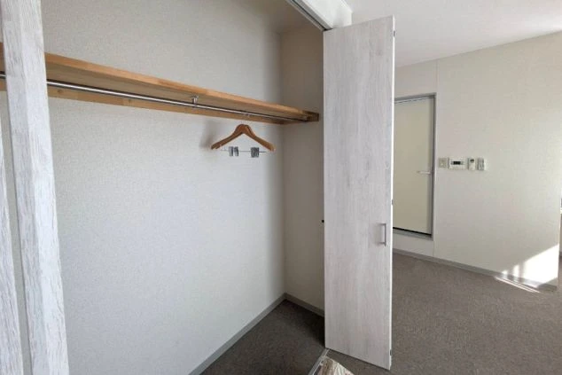 寮の個室にあるクローゼット。ハンガーをかけるポールと棚が設置されている。