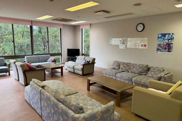 寮の談話室。ソファとテレビが置かれた広い共同スペース。リゾートバイトの仲間と交流できる場所。