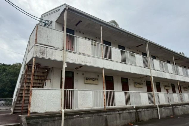 外観。バルコニーが付いた集合住宅で、テーマパークやホテルで働くための住み込み寮。