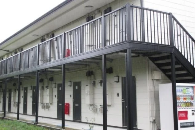 リゾートバイトで働くスタッフが住む寮の外観。黒い手すりのバルコニーが付いたアパートタイプの画像