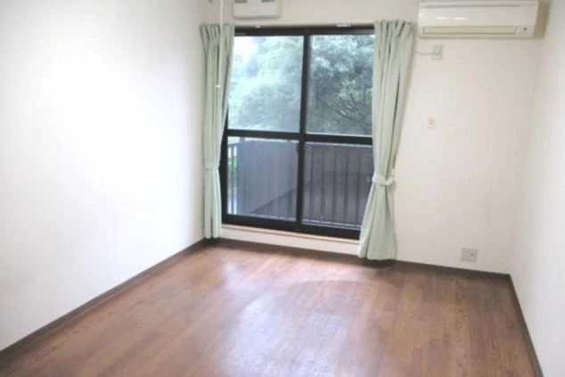 エアコン完備で、窓から光が入る明るいフローリングの寮室内(部屋)の画像