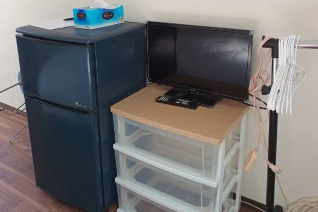リゾートバイトの個室寮の部屋にある設備の画像。冷蔵庫・TV・ハンガーラック・収納が見える。