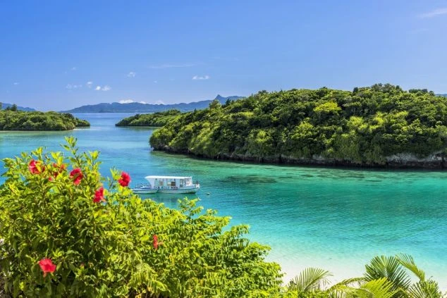 石垣島・川平湾の透明度抜群な海とグラスボート。赤いハイビスカスが彩る南国リゾートバイトの休日観光