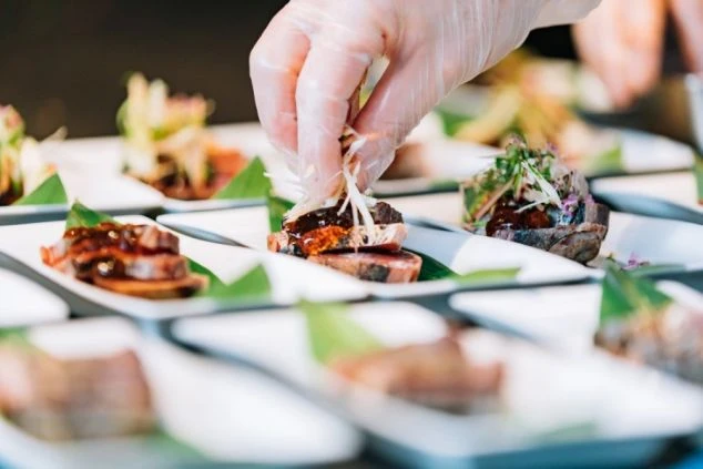 丁寧に料理を仕上げる調理補助スタッフ。