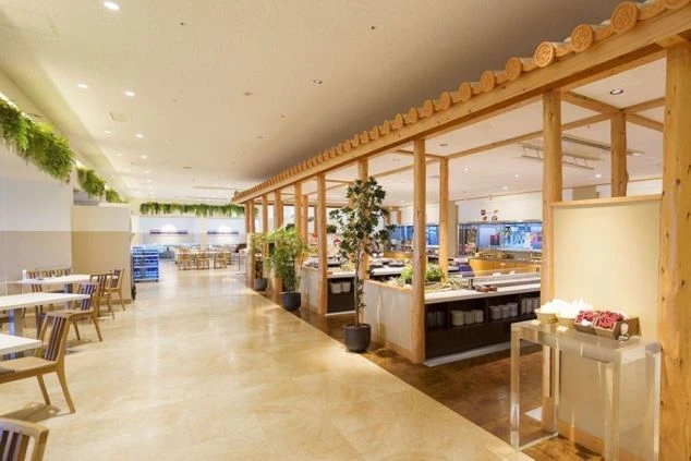 青空の下、サンセットビーチにそびえ立つ勤務先のホテル外観。海が目の前の絶好のロケーションで、沖縄のリゾートバイトを象徴する開放的な景色。