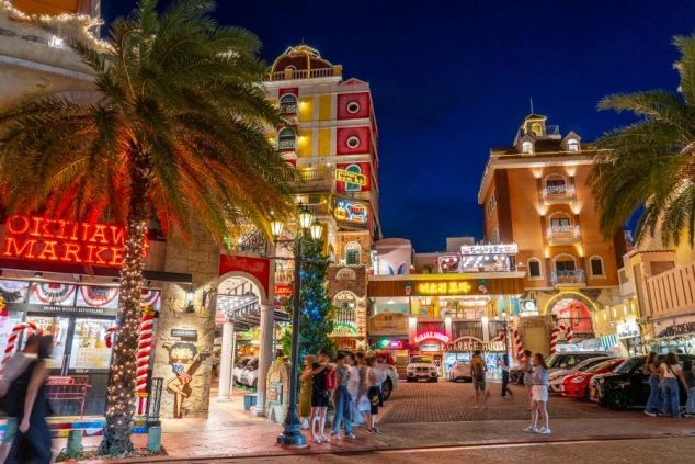 青空の下、サンセットビーチにそびえ立つ勤務先のホテル外観。海が目の前の絶好のロケーションで、沖縄のリゾートバイトを象徴する開放的な景色。