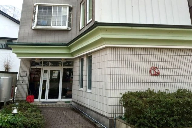 従業員寮の外観。緑の庇が特徴的な、アパートのような建物。