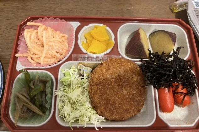 まかないを表現するイメージ画像。コロッケをメインにした、おかずが数種類入ったお弁当。